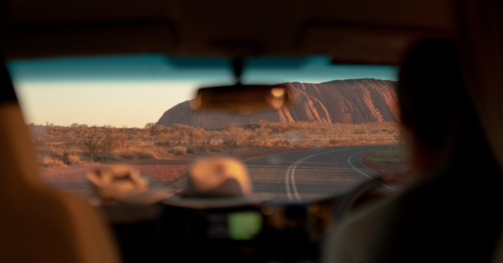 view of uluru from inside a car, road trips